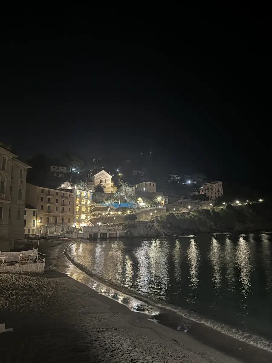 a night time picture of the baia del silenzio lights illuminating the water