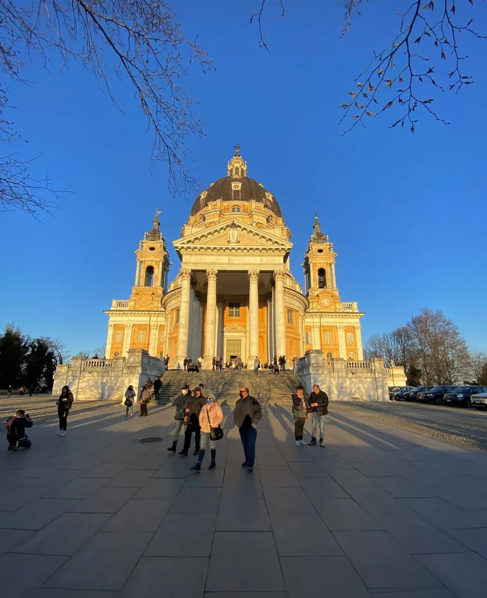 Golden sunset light over the Baroque Basilica of Superga on a hilltop overlooking Turin and the distant Alps.