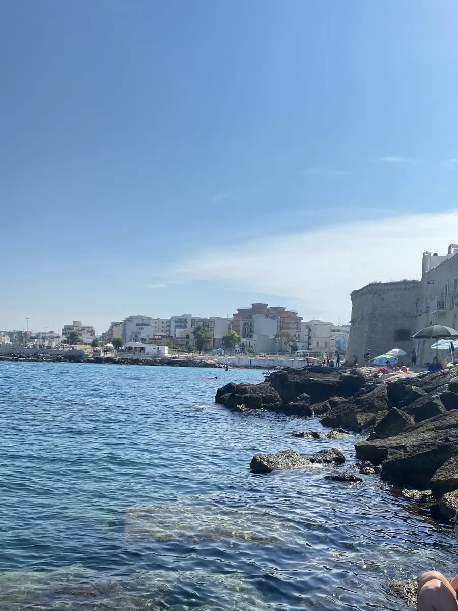 people on the rocks and swimming in the Cala Porta Vecchia Beach monopoli