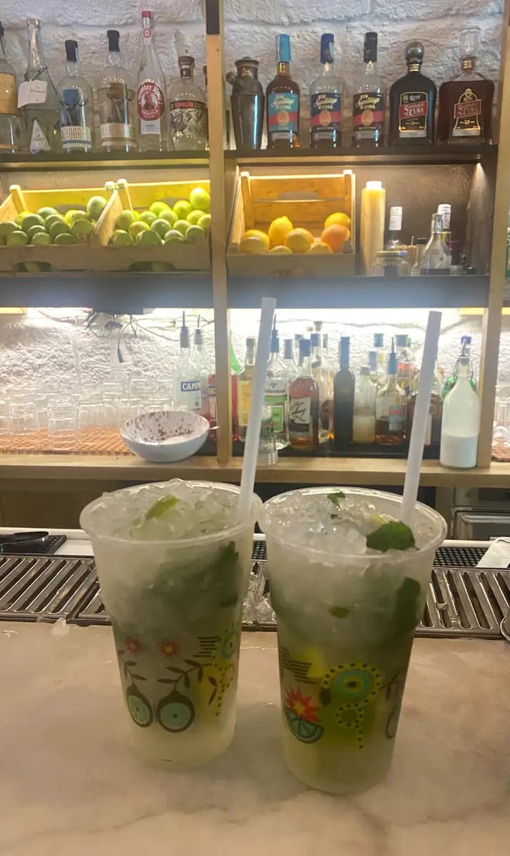 mojitos in la casa del mojito on the bar counter with limes and lemons and liquor in the background