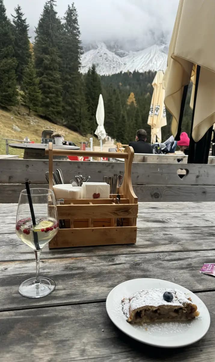 hugo spritz and struddle with the odle peaks in the backround in a table outside at Malga Dusler Alm
