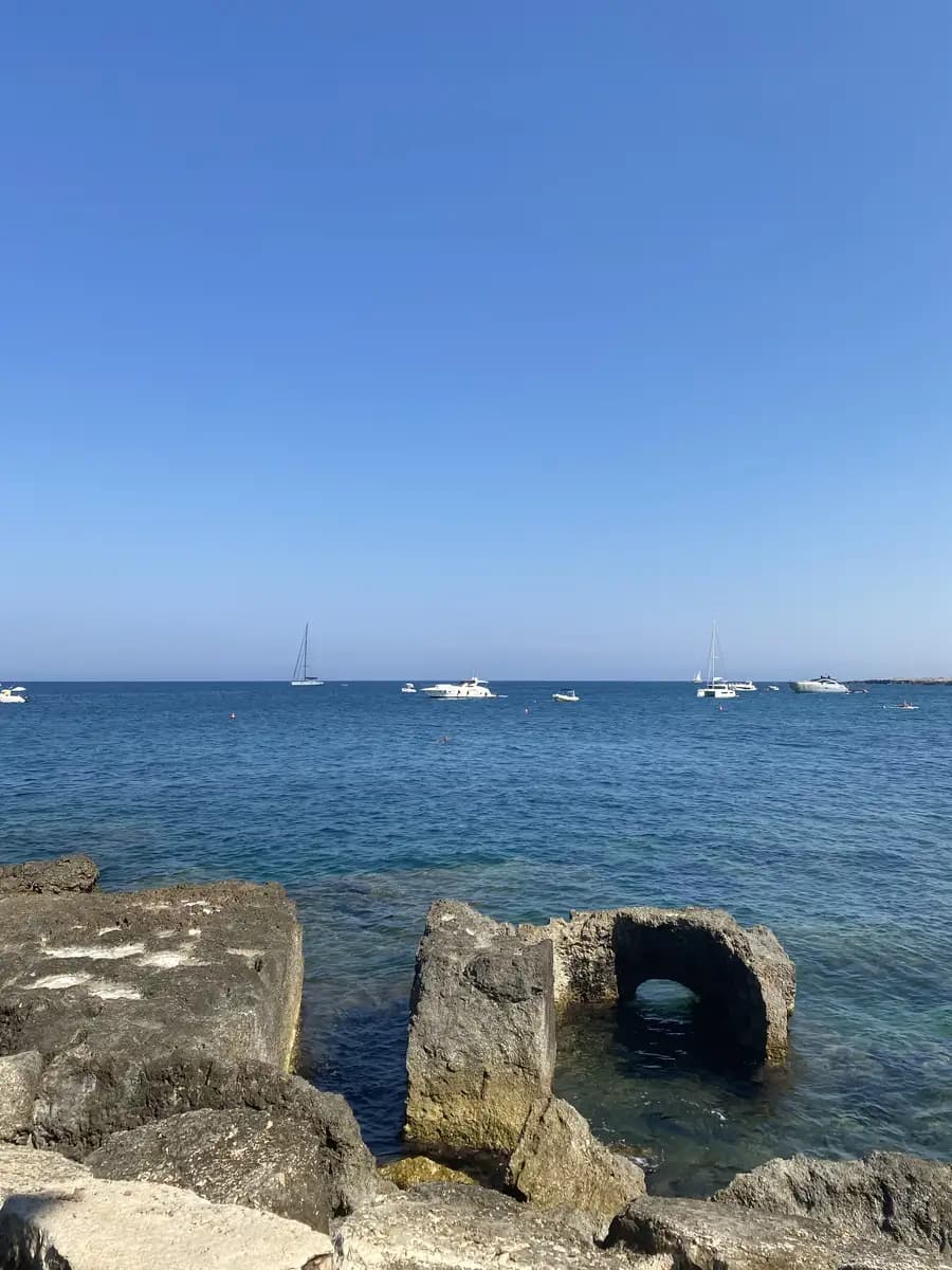 sitting on the rocks getting into the sea in august in puglia