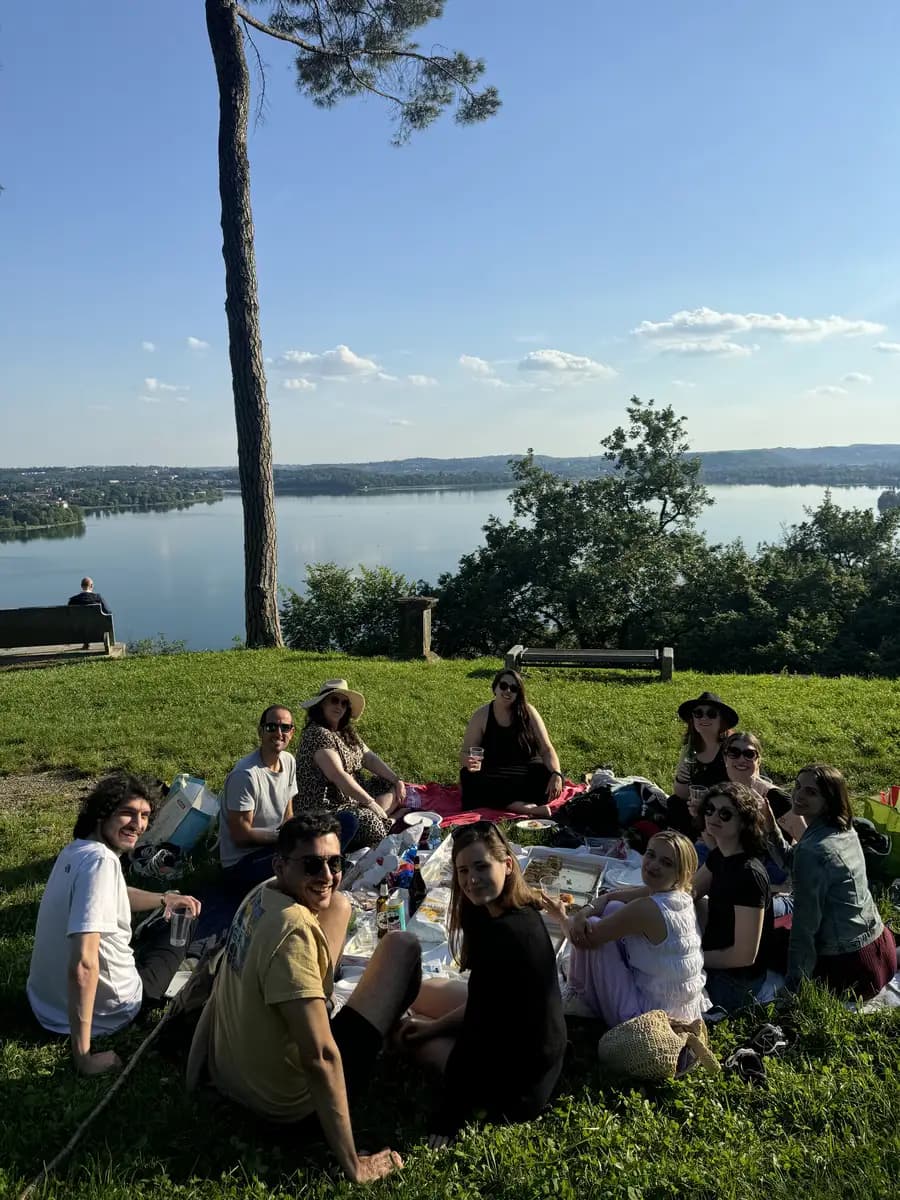 picture of a group of people enjoying a picnic in park roccolo with focaccia and drinks with lake pusiano in the background