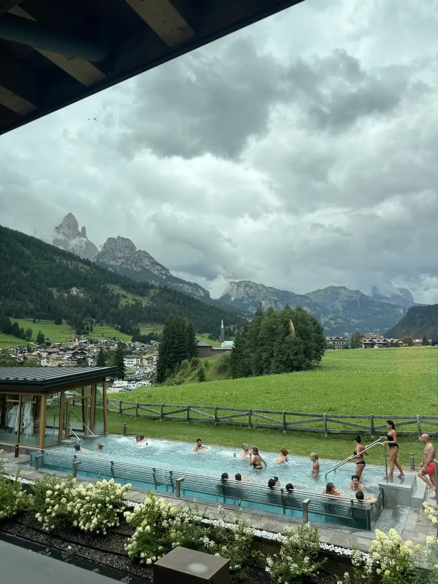 view of the heated outdoor pool and mountains in the qc terme dolomites
