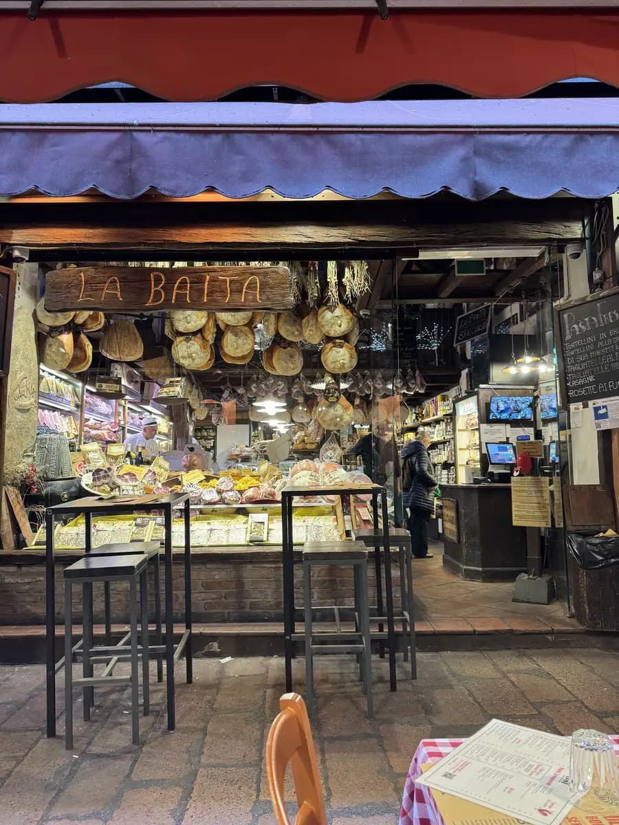 picture of aged parmesan, hanging prosciutto in the window