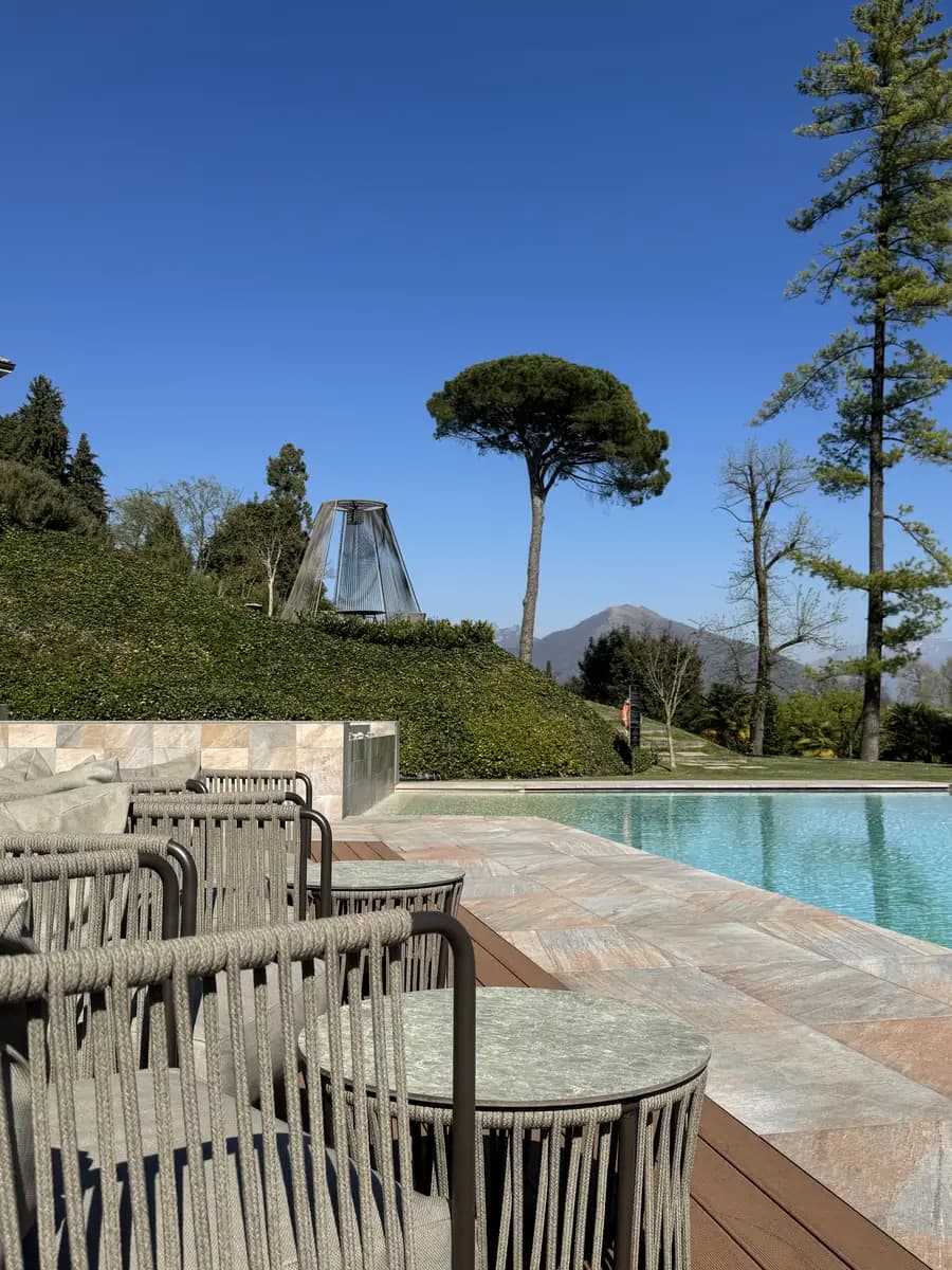 outdoor seats and outdoor pool with trees and mountains in the background