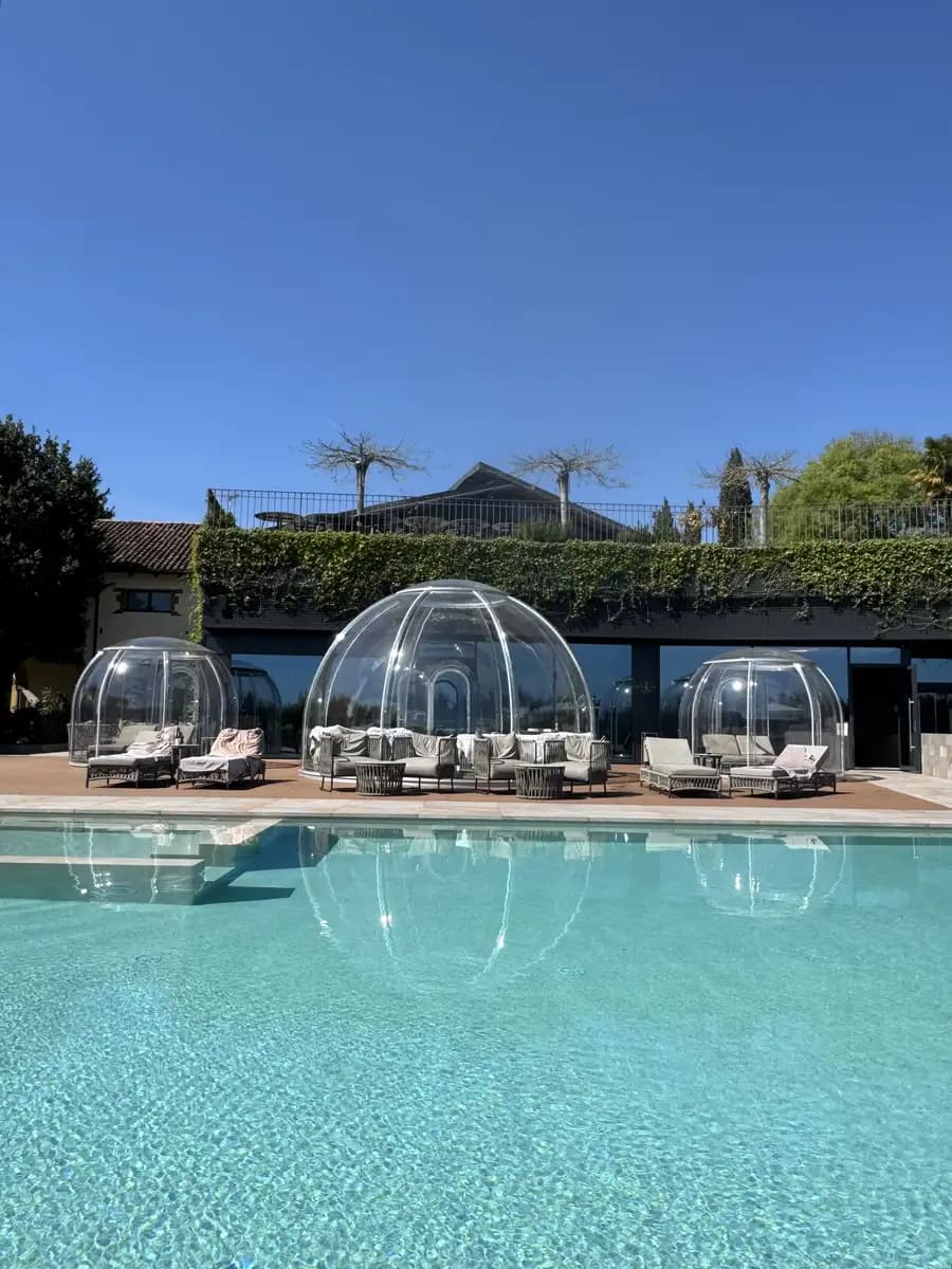 outdoor pool in the spa with the three domes behind it and the sun loungers