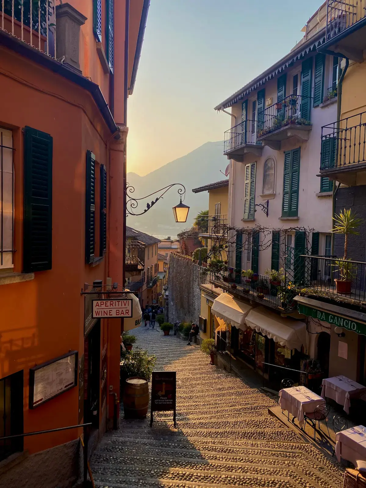 The iconic narrow cobblestone steps of Bellagio, Lake Como, lined with colourful flowers and traditional Italian buildings